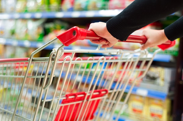 Lady pushing a shopping cart in the supermarket.